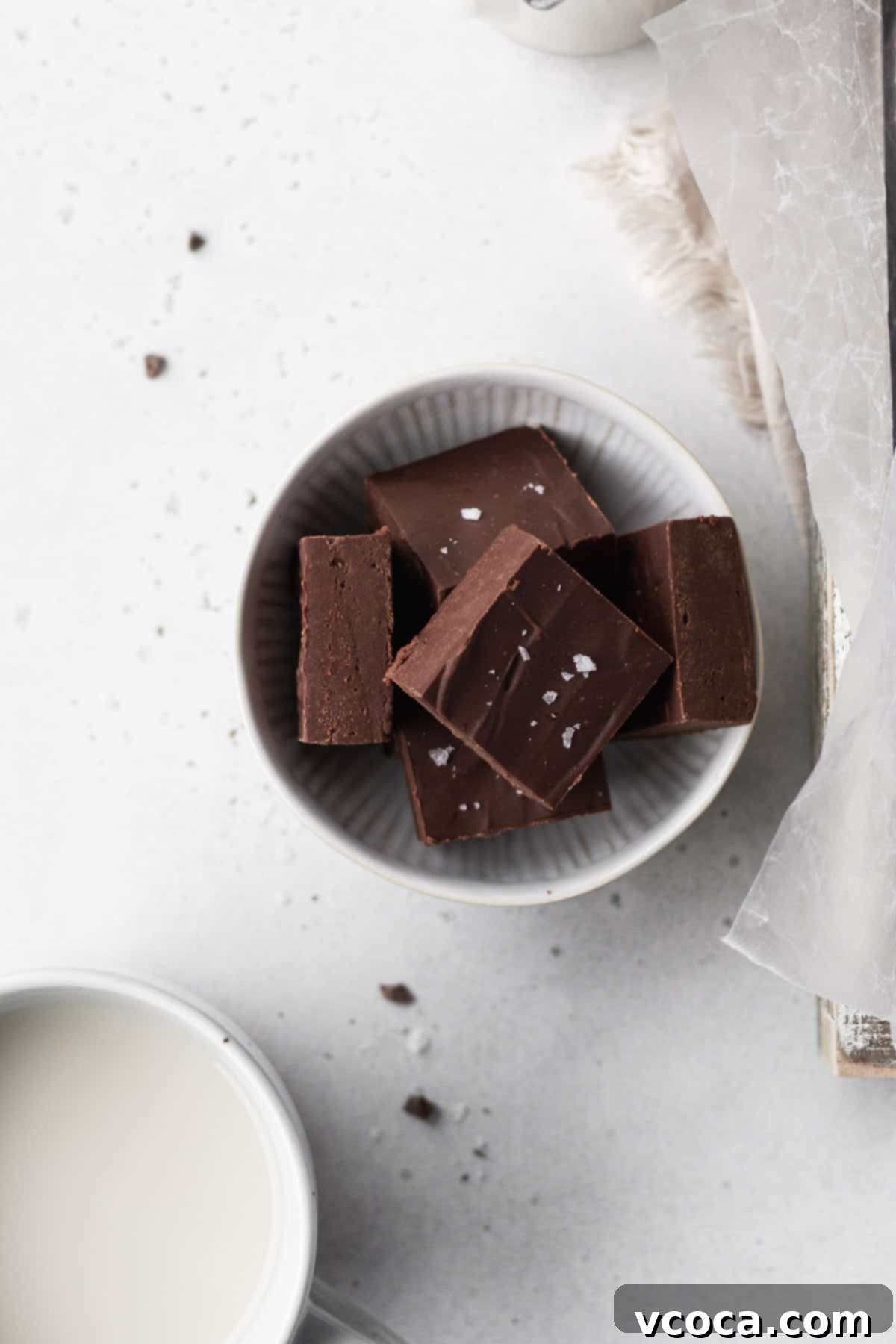 Plant-Based Fudge 11 Overhead shot of cubes of dairy-free fudge in a white bowl on a white table.