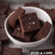 Plant-Based Fudge 12 Closeup shot of cubes of dairy-free fudge in a white bowl and garnished with some flaky sea salt.