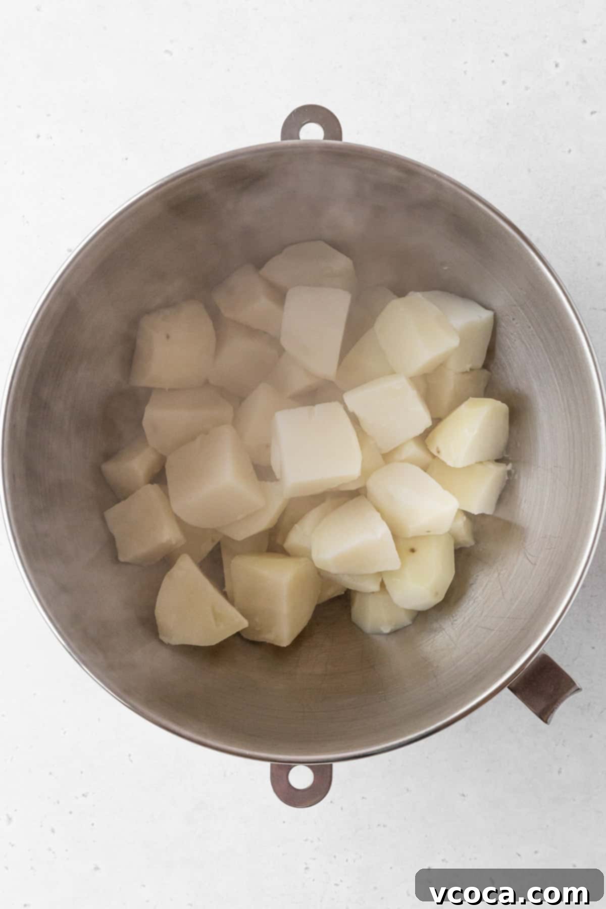 Plant-Powered Potato Croquettes 7 Drained potatoes in a mixing bowl.