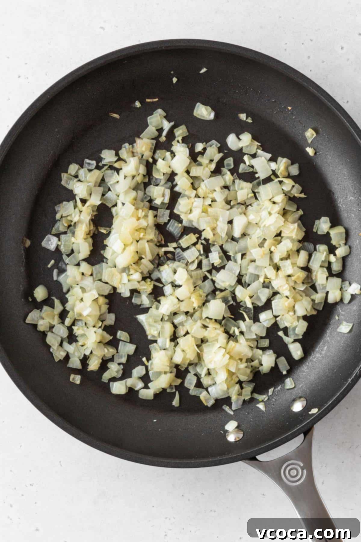 Plant-Powered Potato Croquettes 8 Sautéed diced onions in a pan.