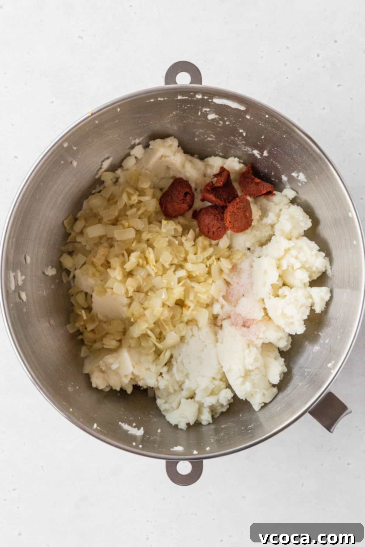 Plant-Powered Potato Croquettes 10 Sautéed onion mix and curry paste added to bowl with mashed potato mix.