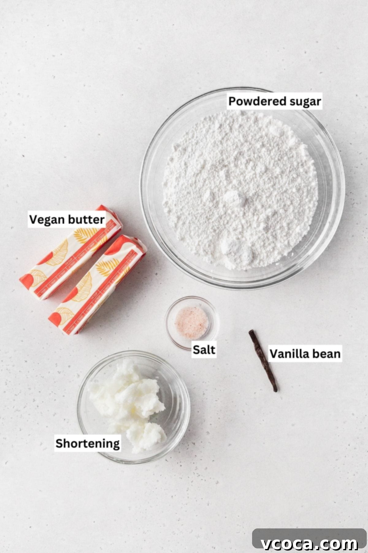 Ingredients for making vegan vanilla buttercream frosting laid out on a white table.