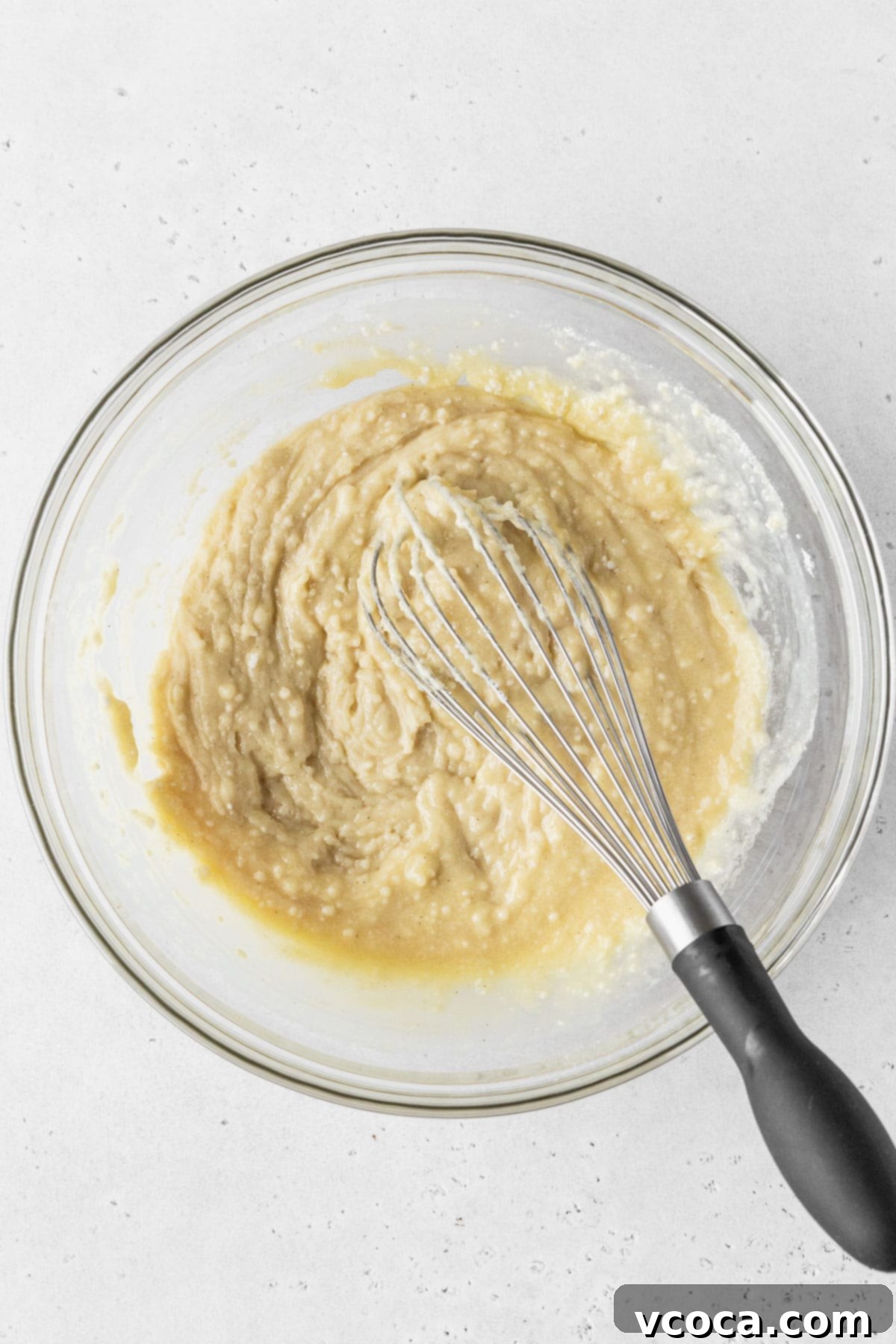 Dry ingredients added to wet ingredients for making dairy-free cupcakes, but the batter is still thick and lumpy because the dairy-free milk is yet to be added.