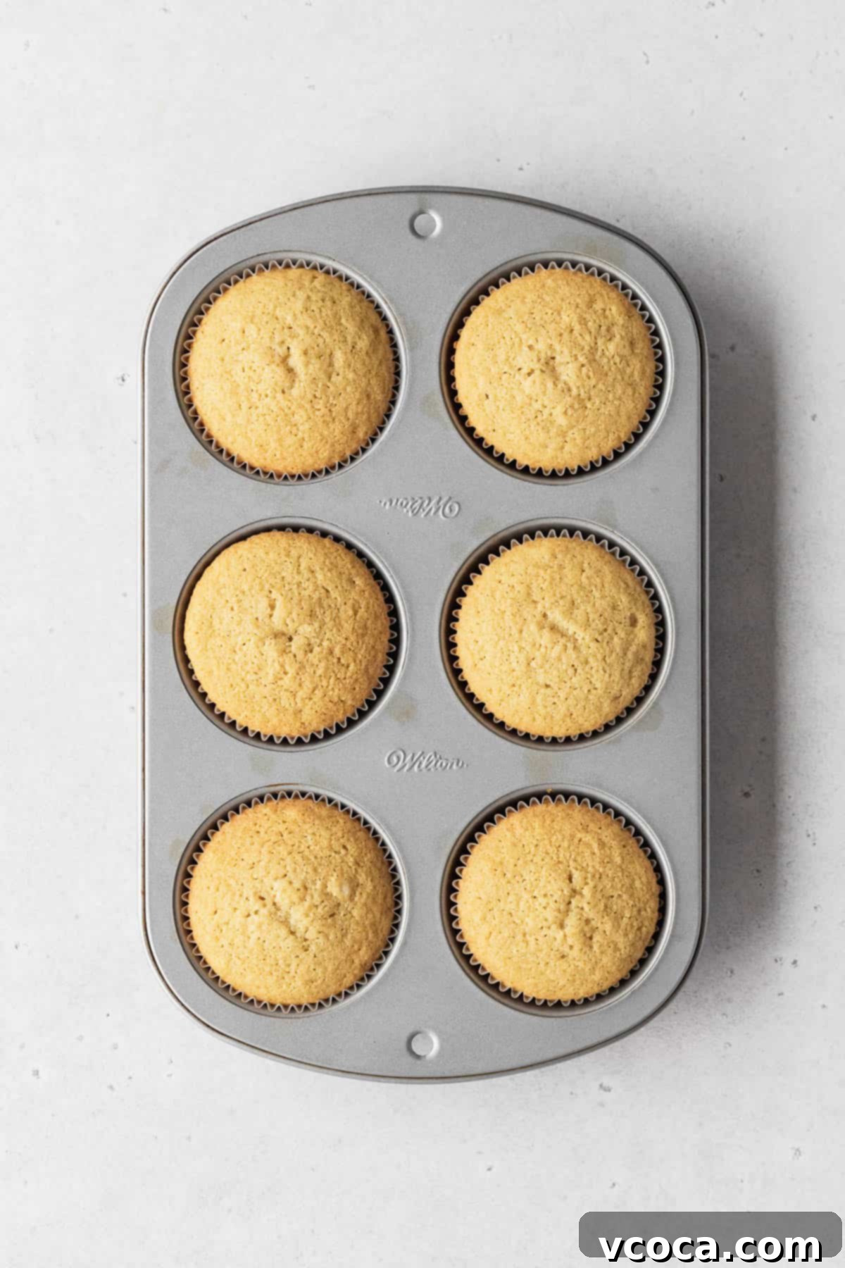 Muffin tin filled with 6 perfectly baked dairy-free vanilla cupcakes.