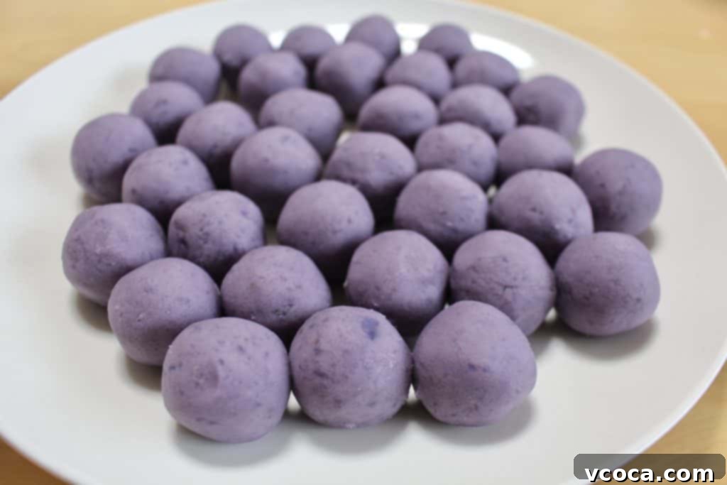 Purple sweet potato balls, perfectly rolled and ready to be covered with white chocolate for Halloween treats.