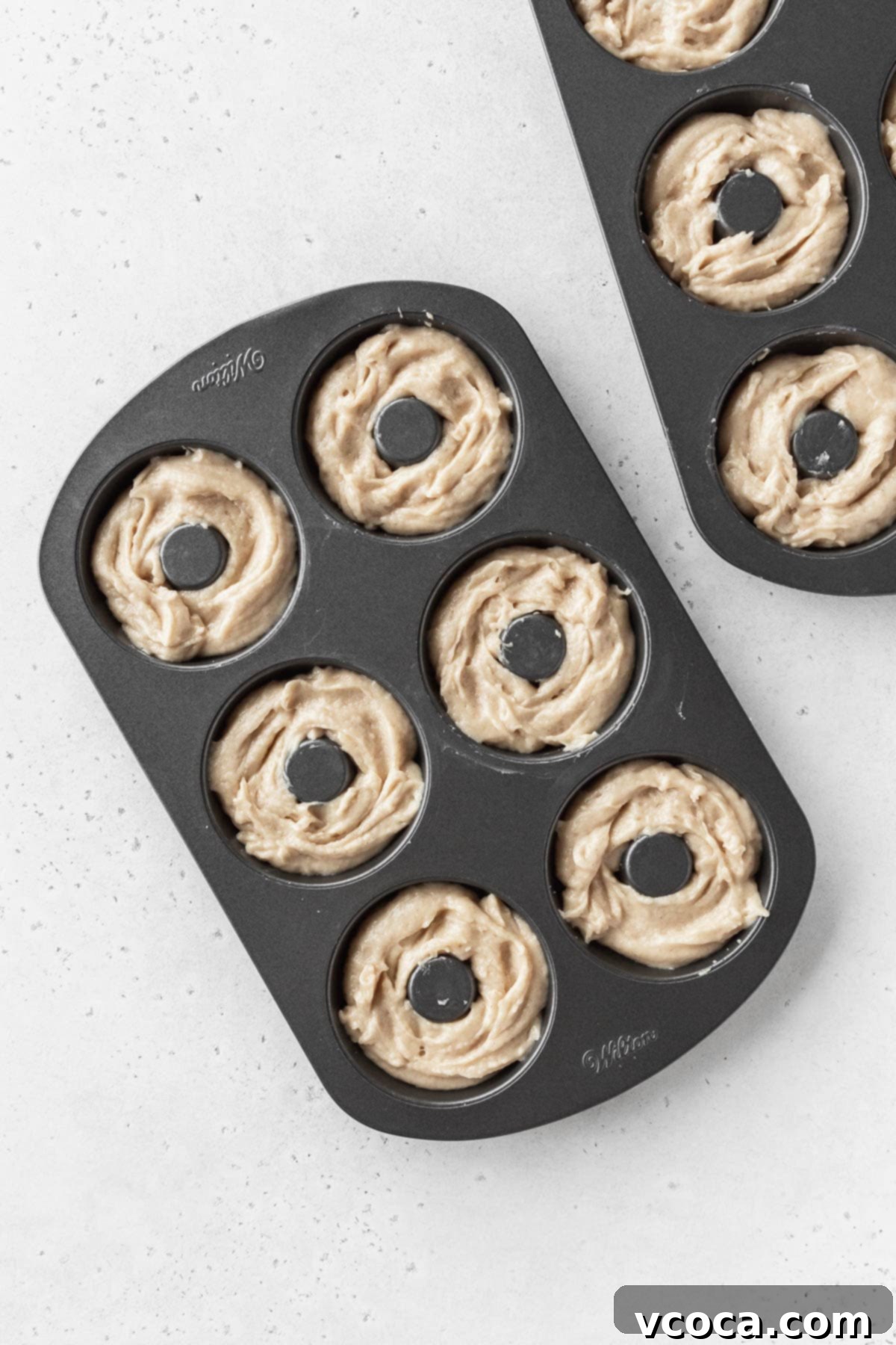 Wholesome Plant-Based Baked Donuts 8 Overhead shot of unbaked dairy-free donut batter in two donut pans.