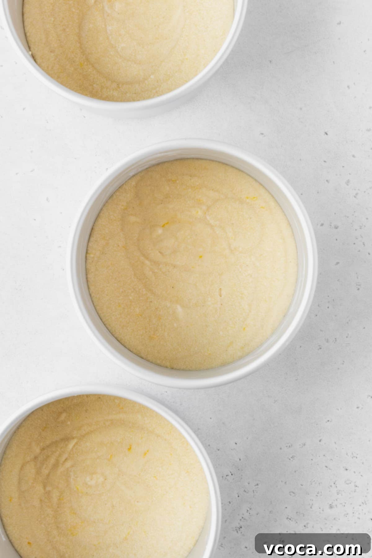 Luscious Lemon Curd Cake 18 Three 6-inch cake tins filled with lemon cake batter before baking.