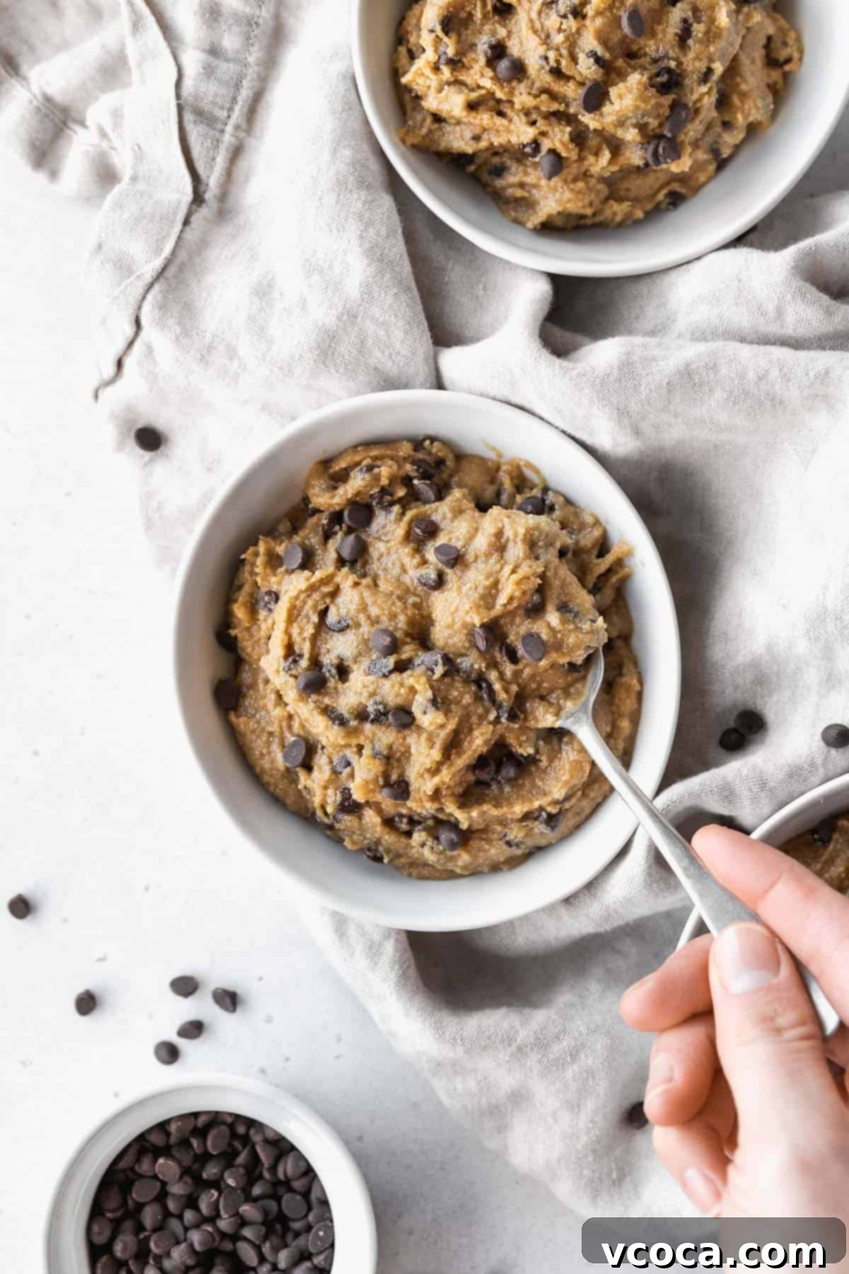 No-Bake Gluten-Free Cookie Dough 2 Hand taking a spoonful of gluten-free edible cookie dough from the bowl.