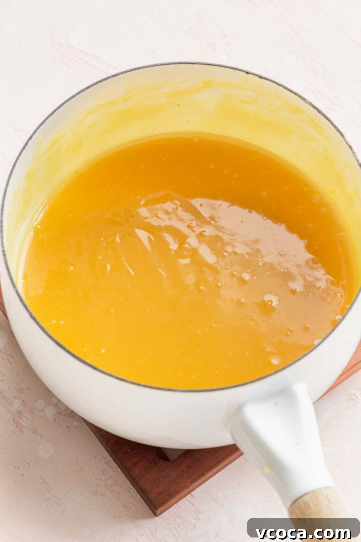 completed lemon curd in a sauce pan, bright yellow like the color of an egg yolk, ready to be cooled and served.