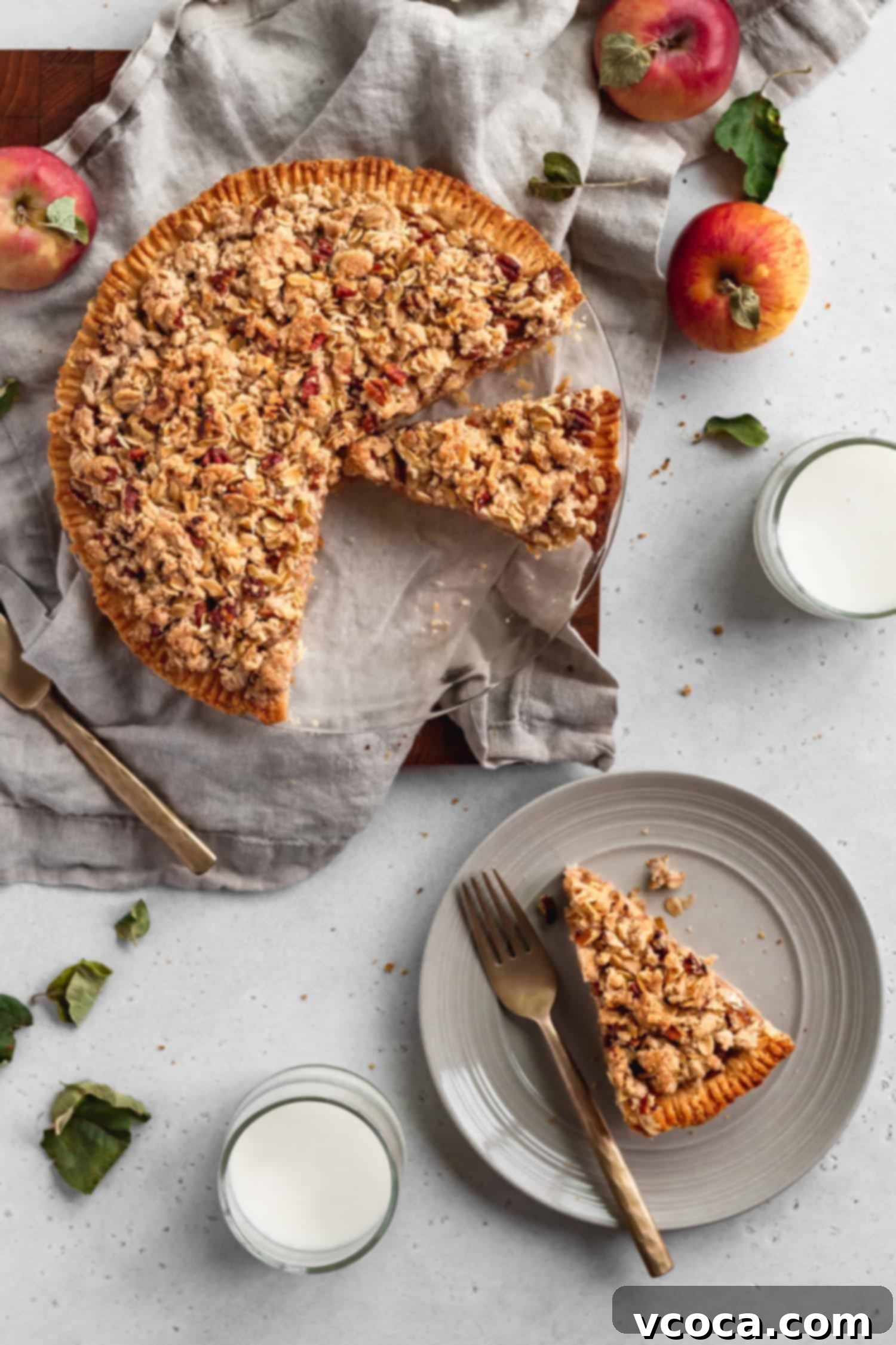Gluten Free Dutch Apple Crumble Pie 3 A slice of gluten-free Dutch apple pie on a white plate with a fork, showcasing the rich apple filling and crunchy streusel