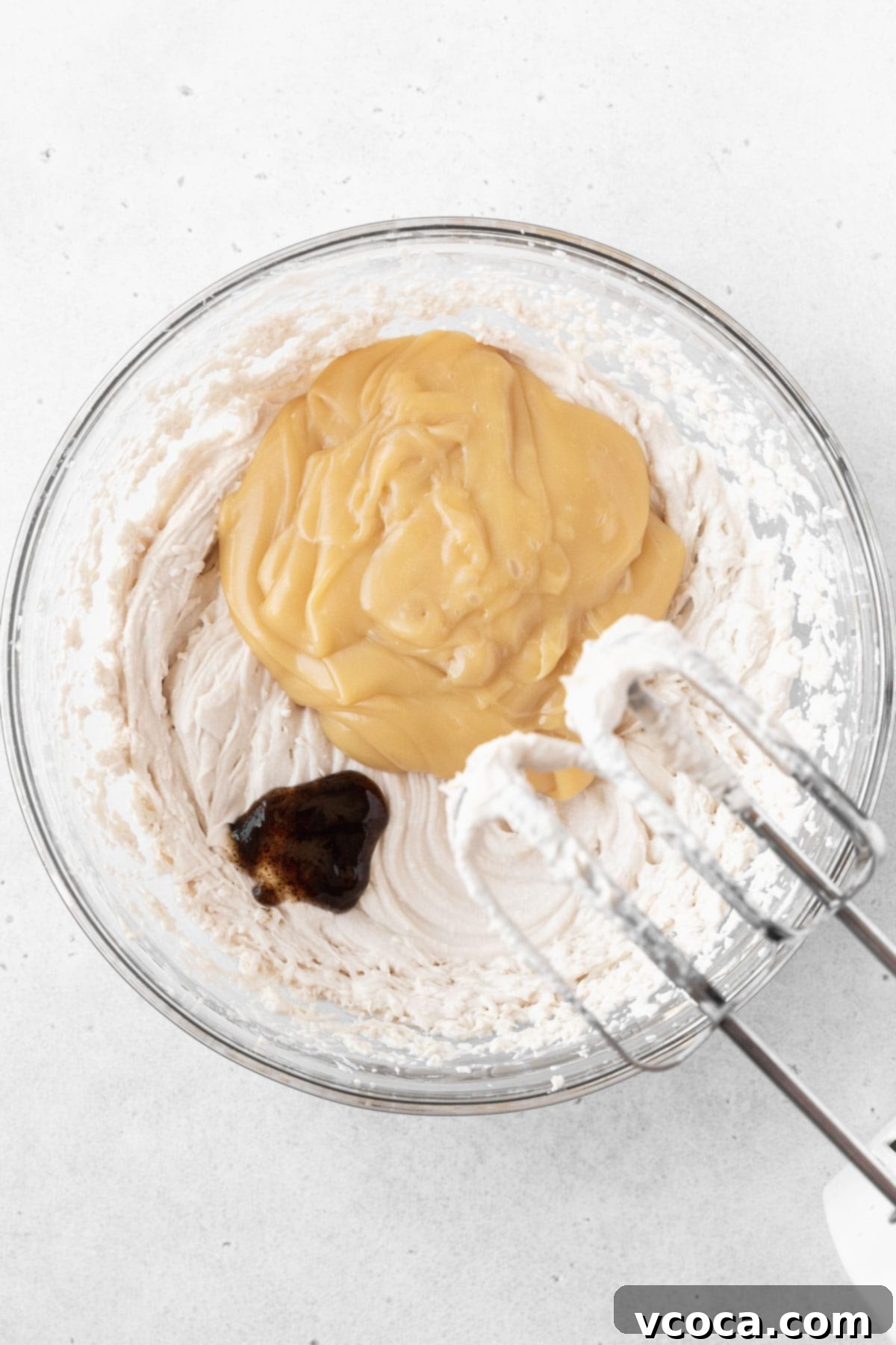 Guilt-Free Frozen Indulgence 11 Adding the sweetened condensed oat milk and vanilla to the glass mixing bowl.