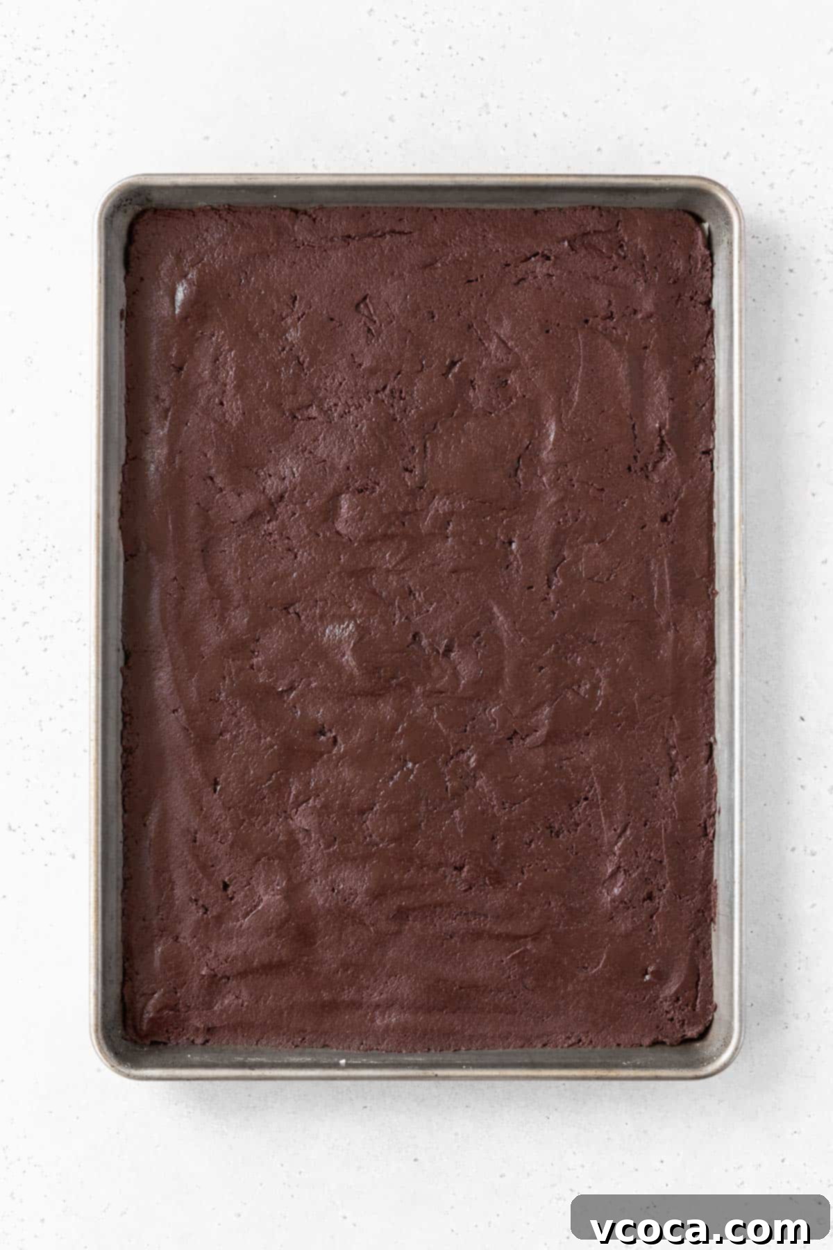 Guilt-Free Frozen Indulgence 8 Chocolate sandwich cookie batter spread out on a baking sheet.