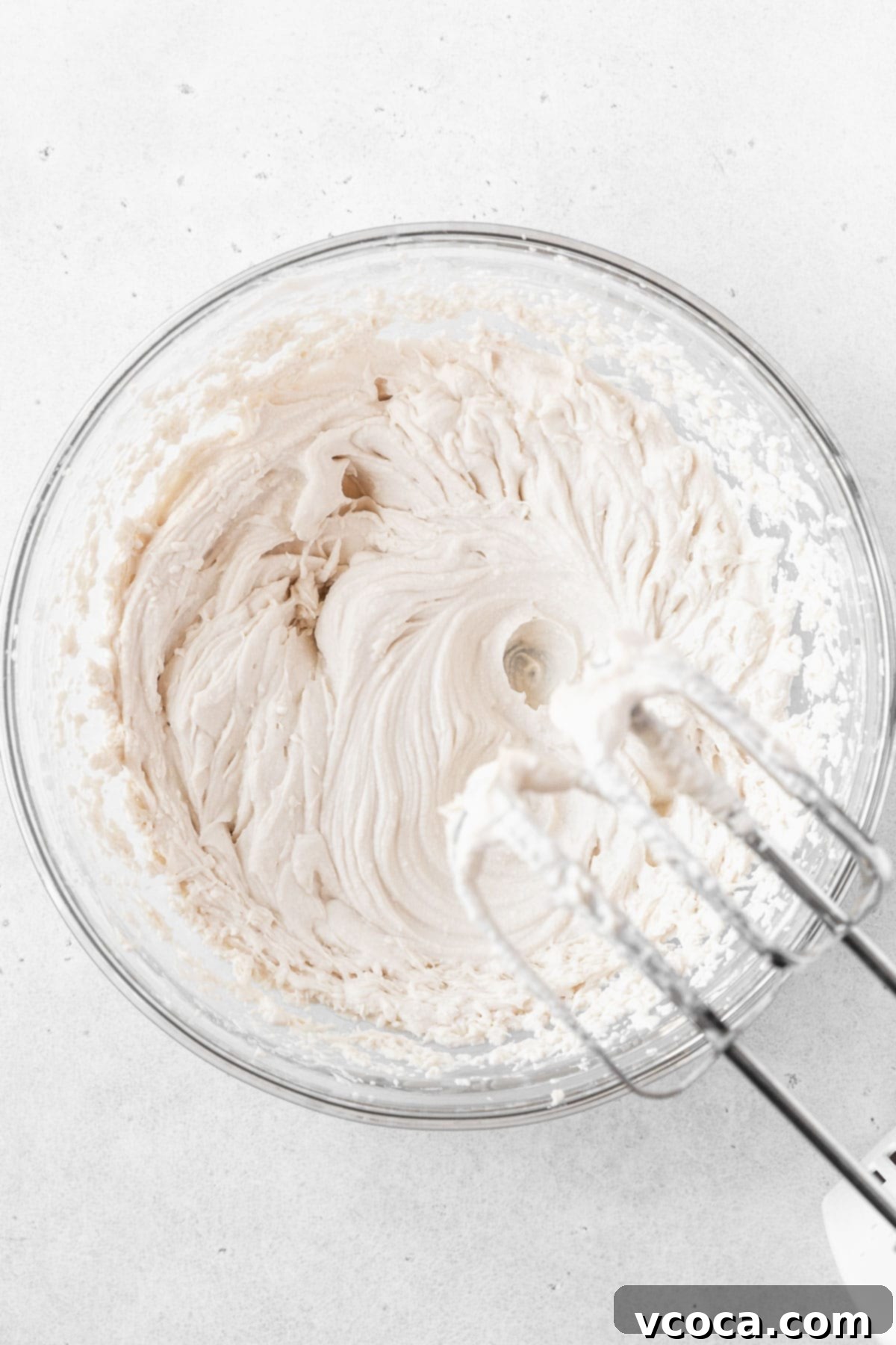 Guilt-Free Frozen Indulgence 10 Whipping up oat milk whipping cream in a glass mixing bowl.
