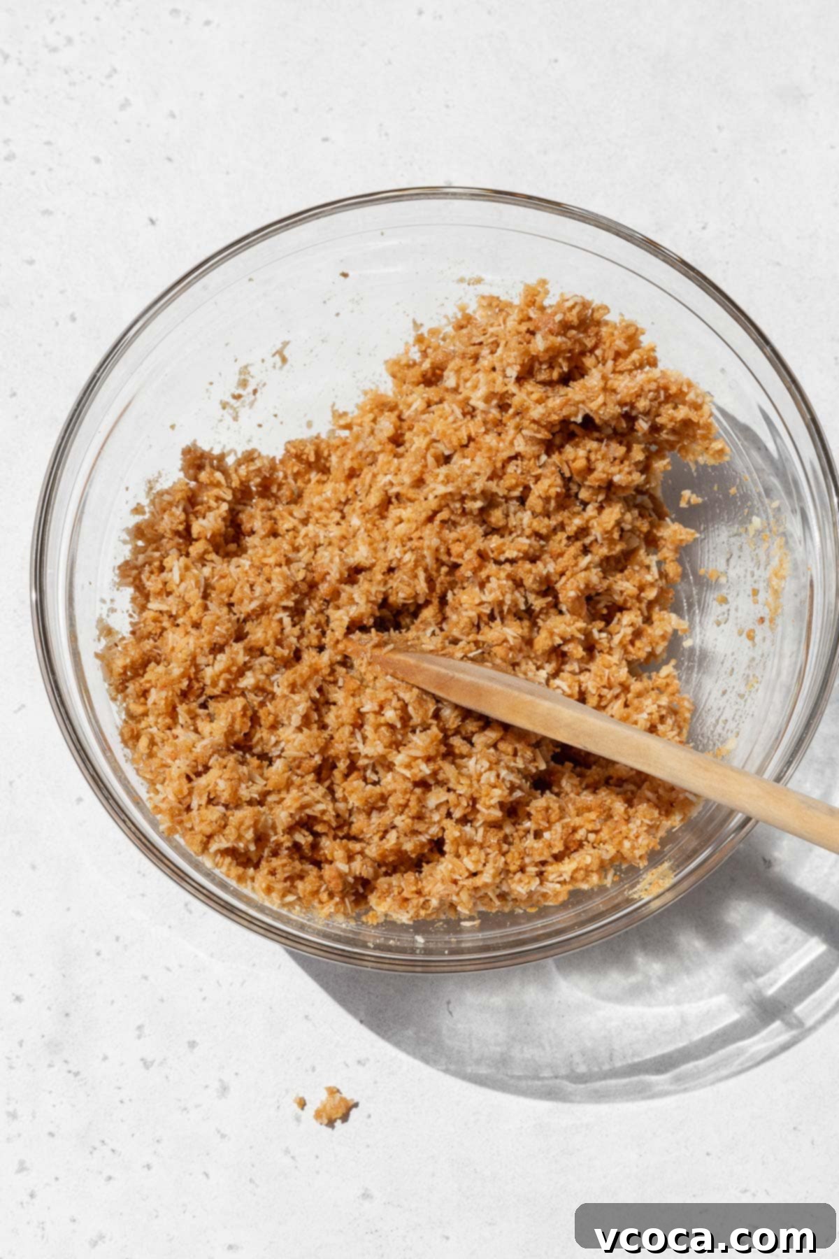 Divine Vegan Coconut Cream Pie Gluten Free 6 Gluten-free coconut pie crust mixture in a bowl after adding the vegan butter. It looks like wet sand.