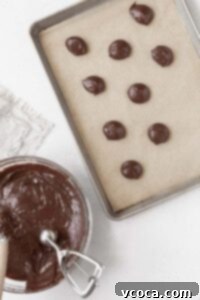 Scooping the gluten-free whoopie pie batter onto a parchment paper lined baking sheet.