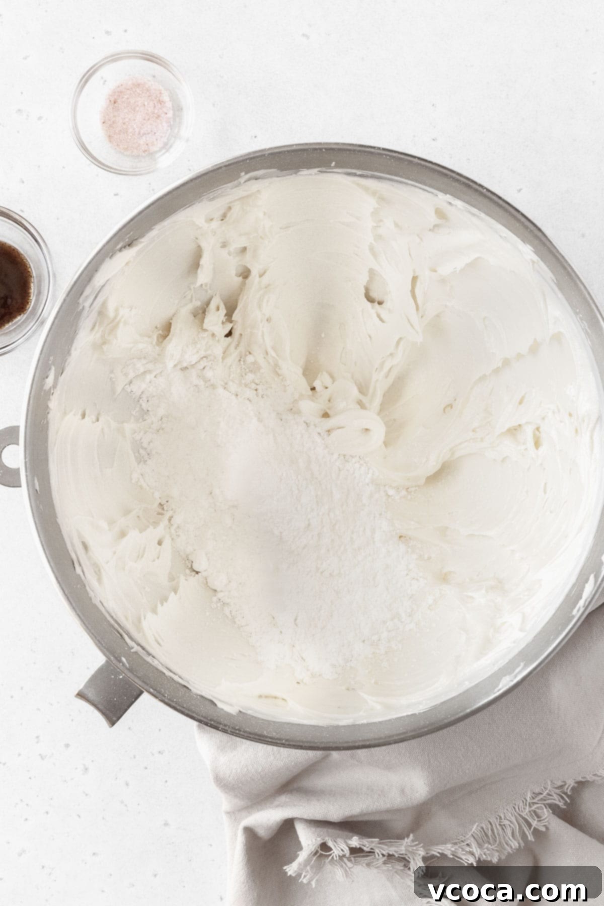 Velvety Vegan Buttercream 6 Powdered sugar being added to the large bowl of whipped butter.