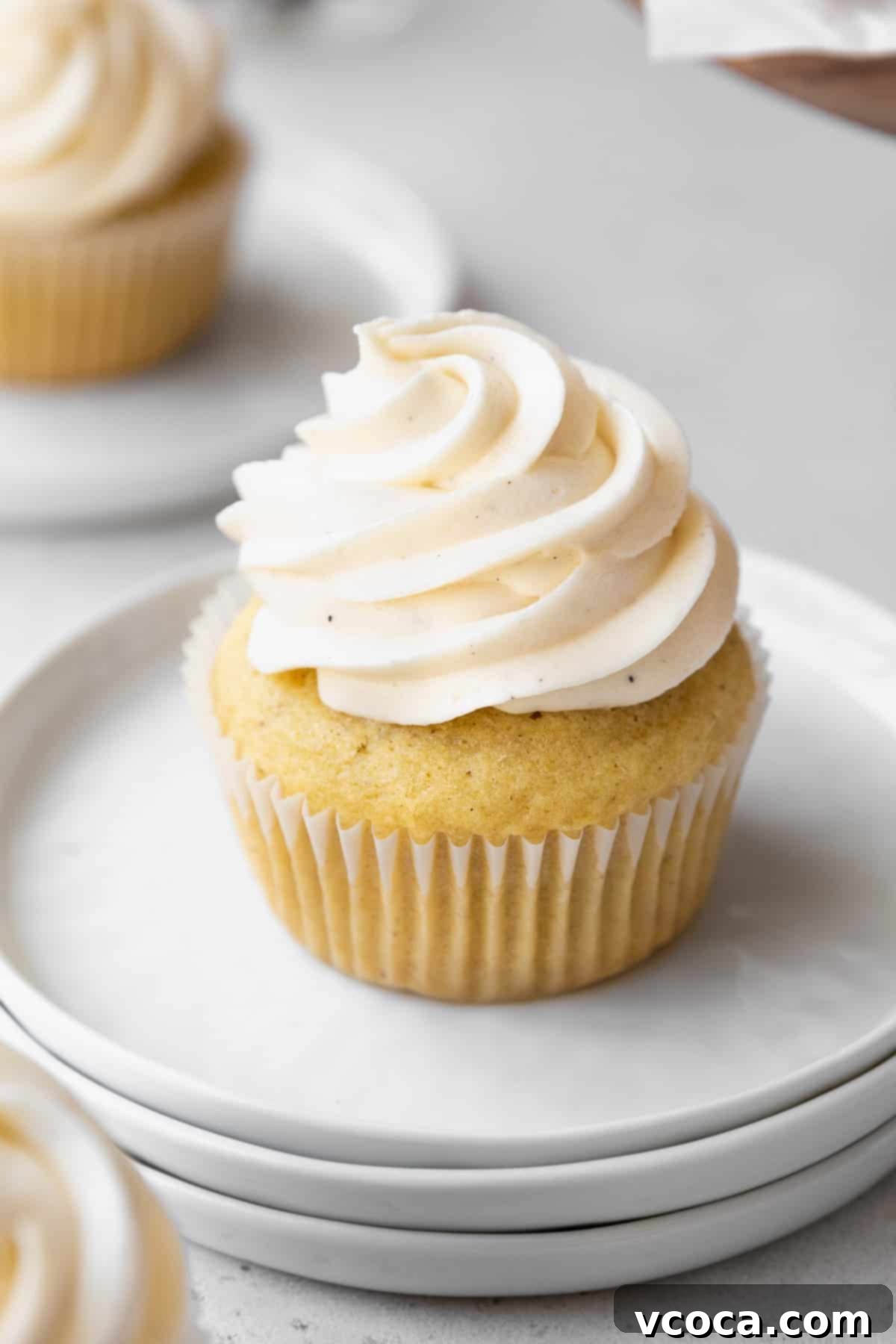 Velvety Vegan Buttercream 8 45 degree angle shot of dairy-free vegan frosting piped into a high swirl on homemade vanilla bean cupcakes.