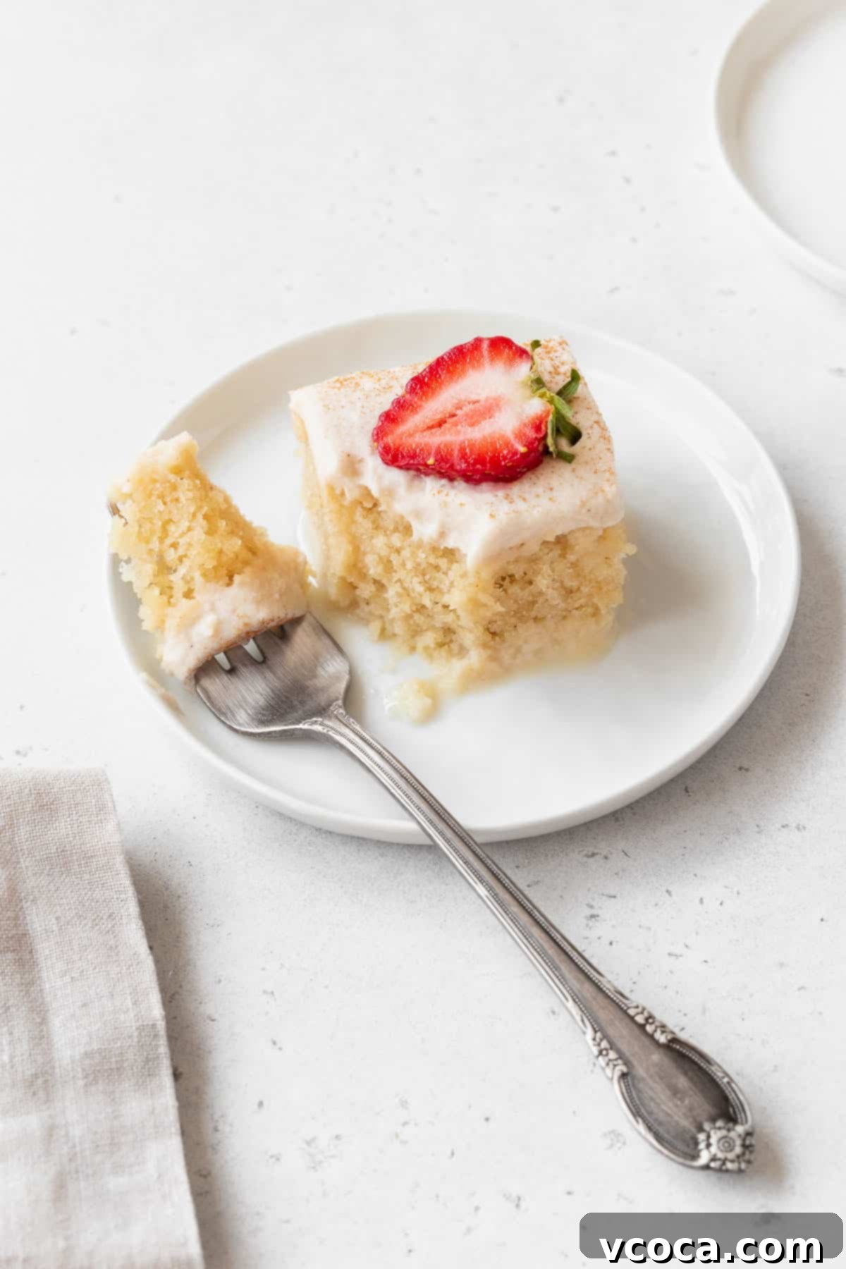 A delicious moment captured: taking a bite out of a luscious piece of gluten-free and dairy-free tres leches cake, showcasing its moist texture and inviting flavor, a true delight for dessert lovers.
