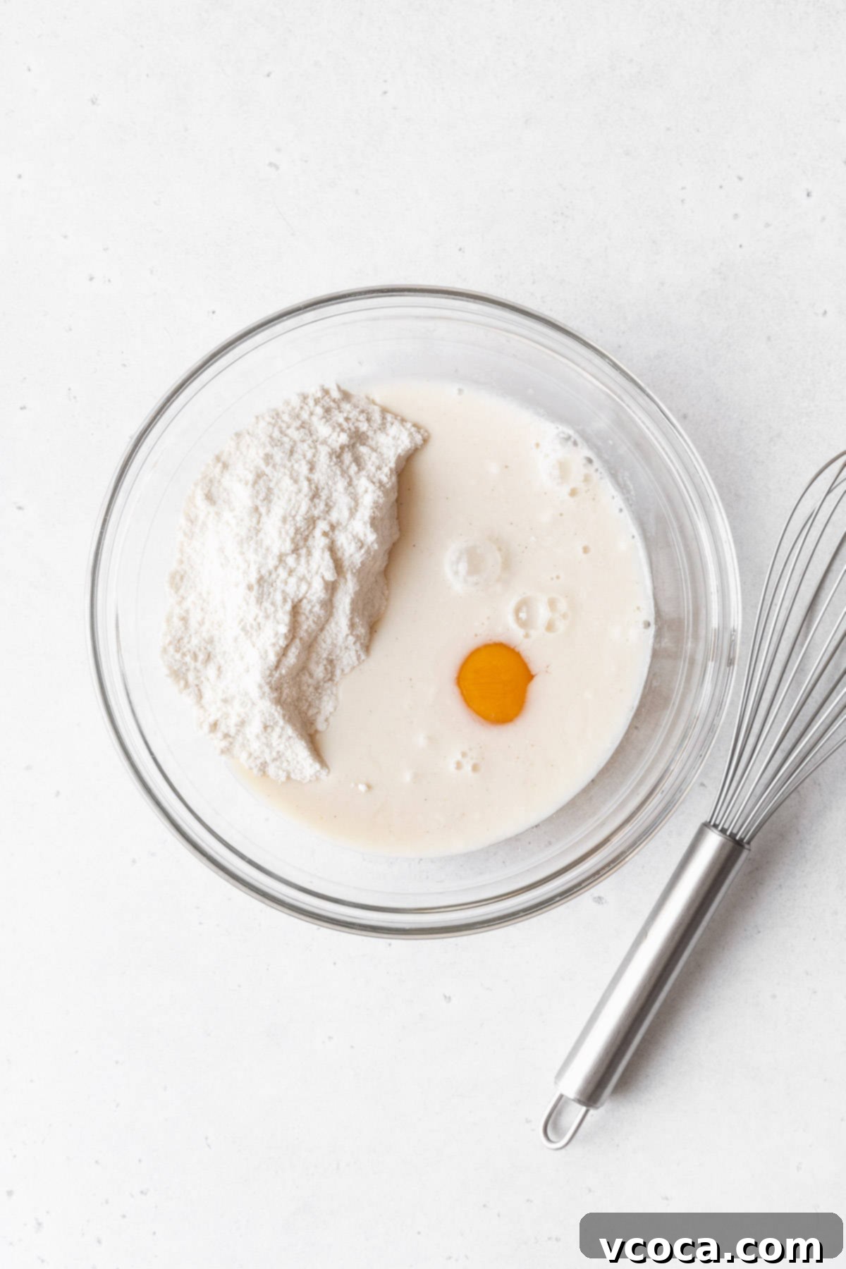 Muffin mix, egg, and milk added to a mixing bowl.