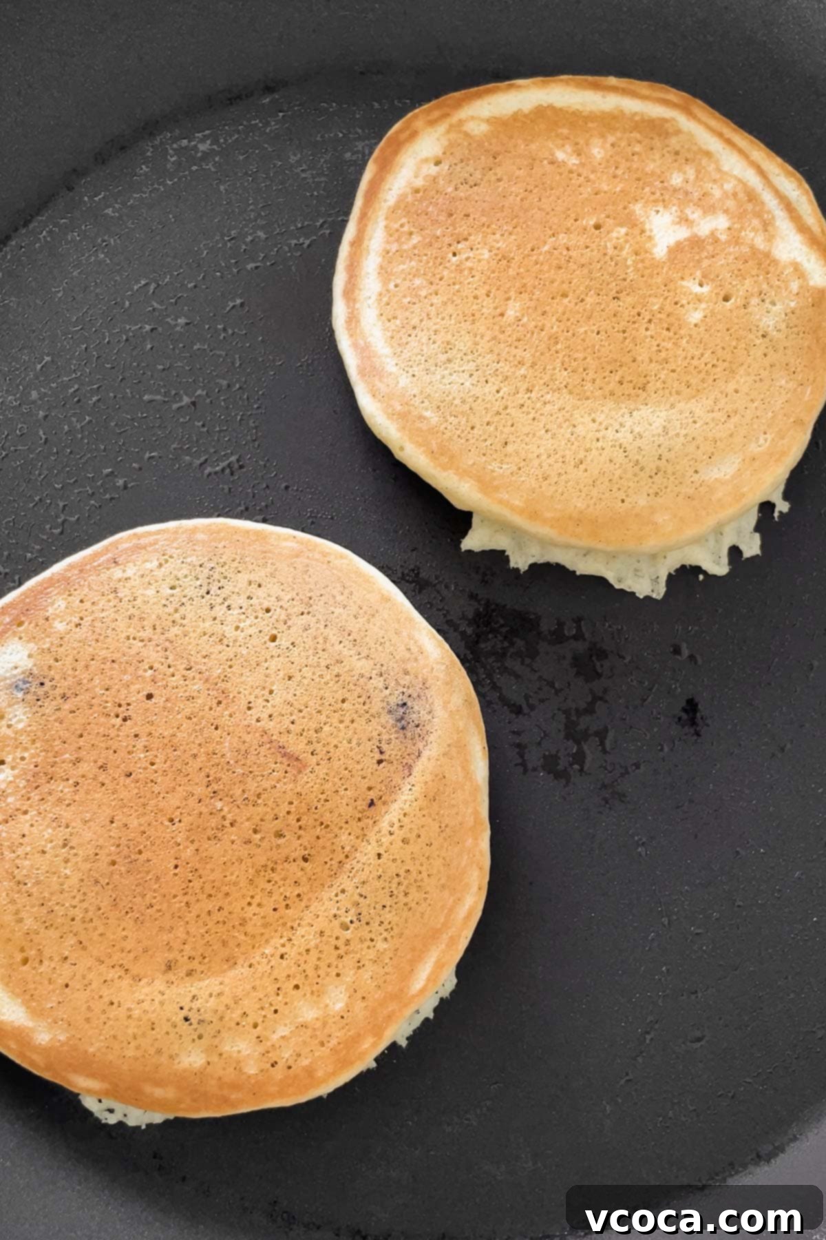 Process shot of the golden muffin mix pancakes after flipping in the skillet.