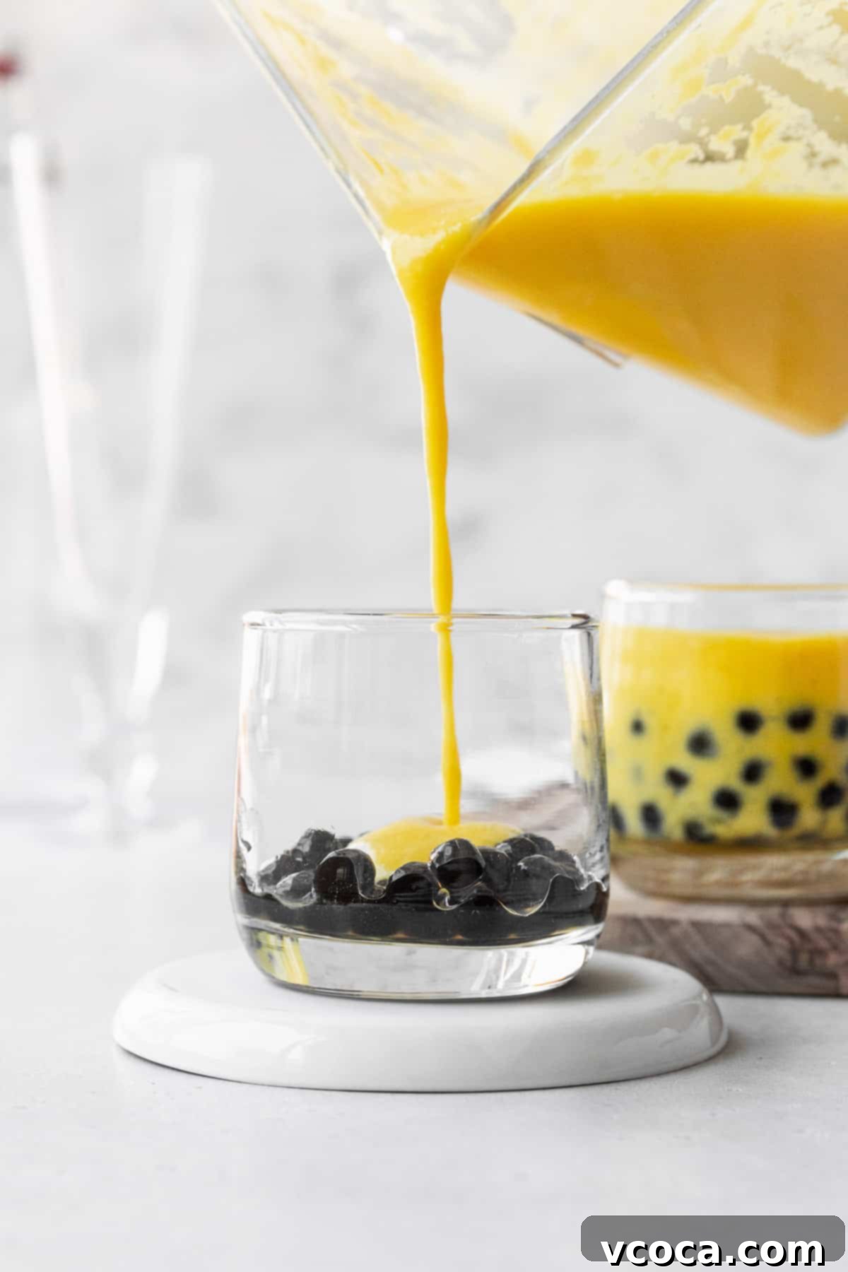 Tropical Mango Boba 11 Pouring the mango puree into a small glass with the boba pearls.
