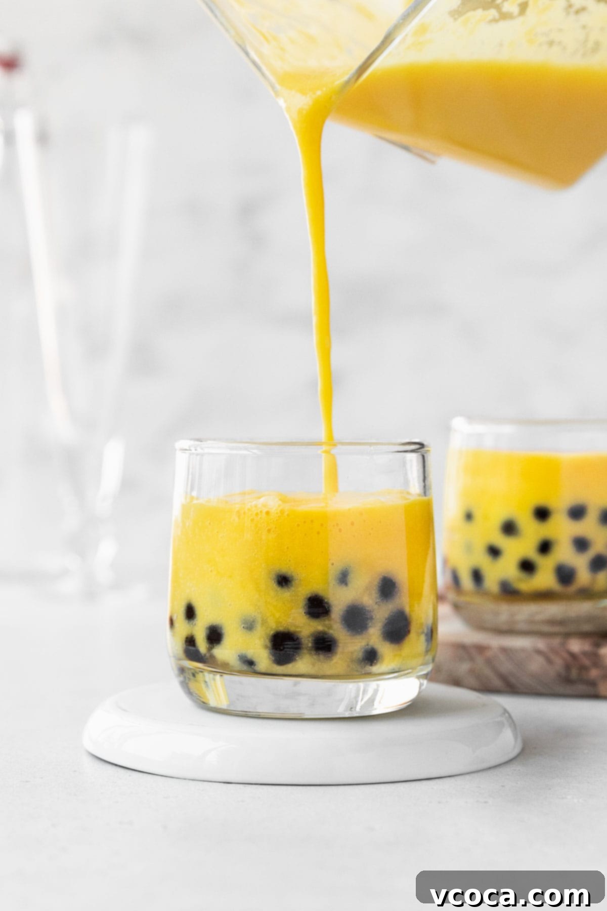 Tropical Mango Boba 12 Filling up a small glass with mango boba tea.