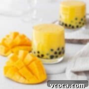Tropical Mango Boba 15 Two glasses of mango boba tea with a sliced mango.