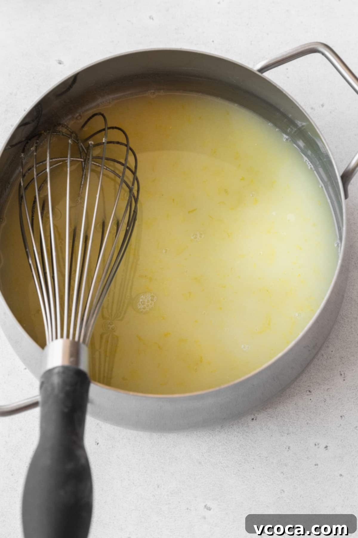 Bright and Zesty Dairy Free Lemon Bars 12 Whisked lemon juice, zest, and sugar mixture in a pot, thickening over heat.