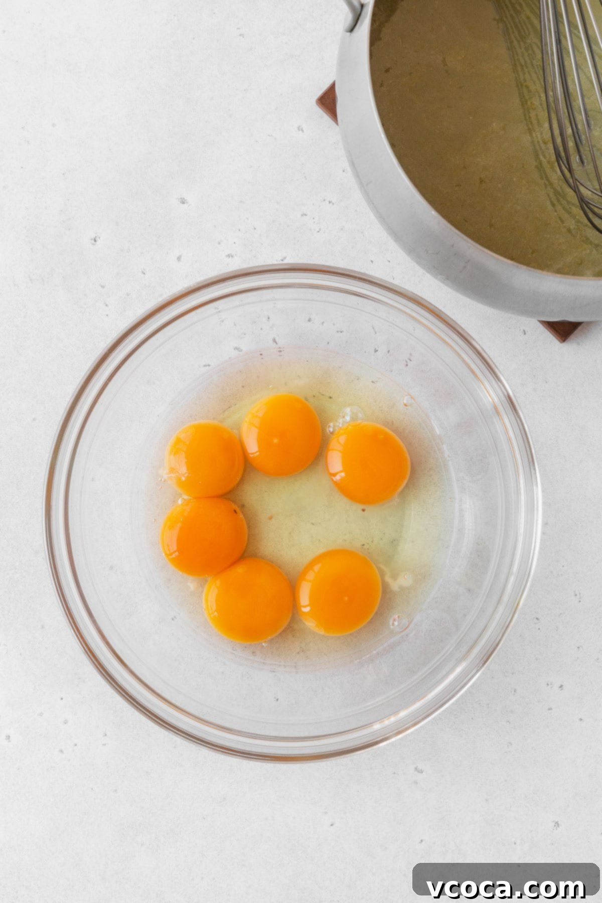 Bright and Zesty Dairy Free Lemon Bars 13 6 egg yolks in a glass mixing bowl on the counter, ready for whisking.