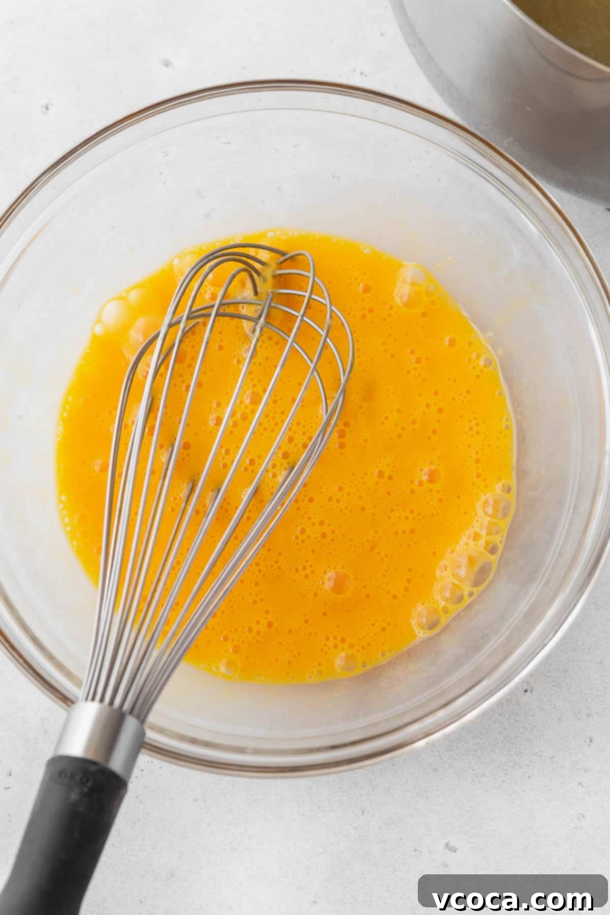 Bright and Zesty Dairy Free Lemon Bars 14 Whisked egg yolks in a glass bowl with a whisk, after tempering with hot lemon mixture.