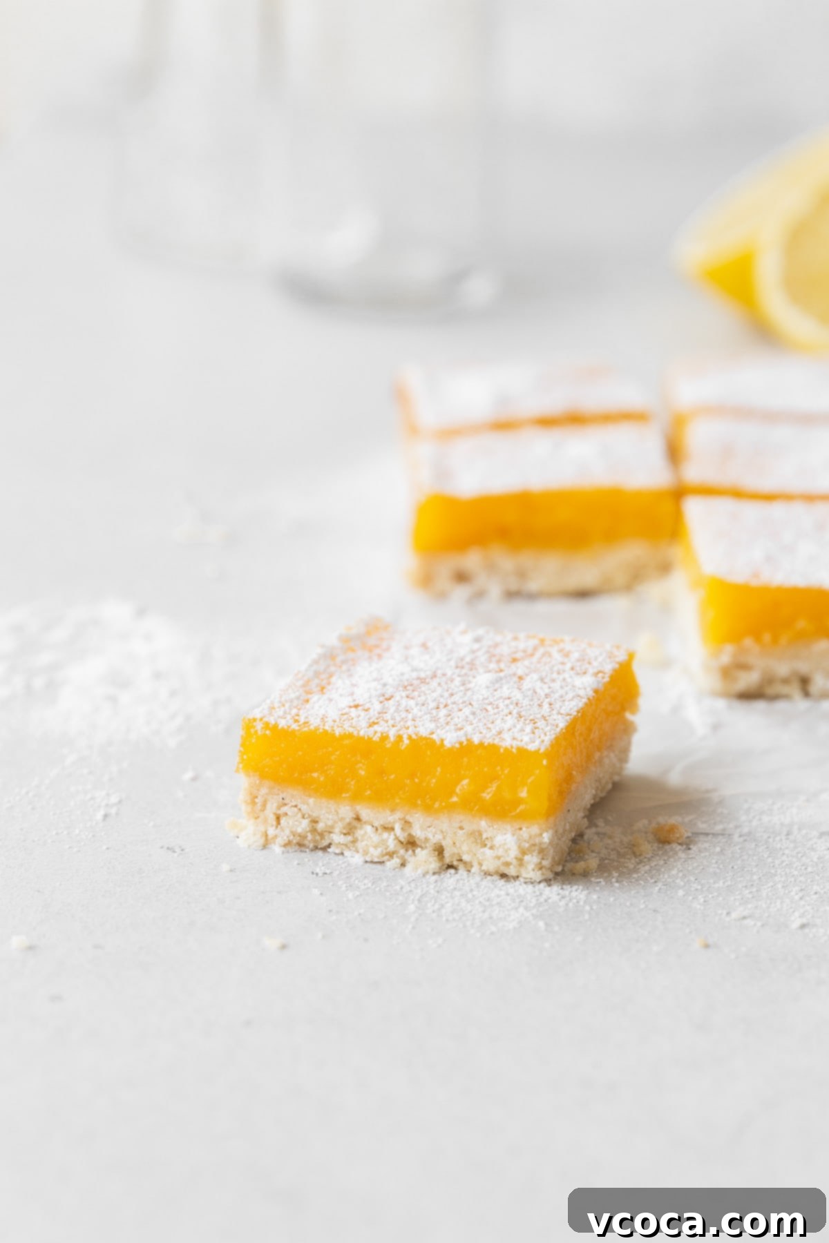 Bright and Zesty Dairy Free Lemon Bars 21 A side shot of perfectly cut dairy-free lemon bars on the counter, showcasing the crust and filling.