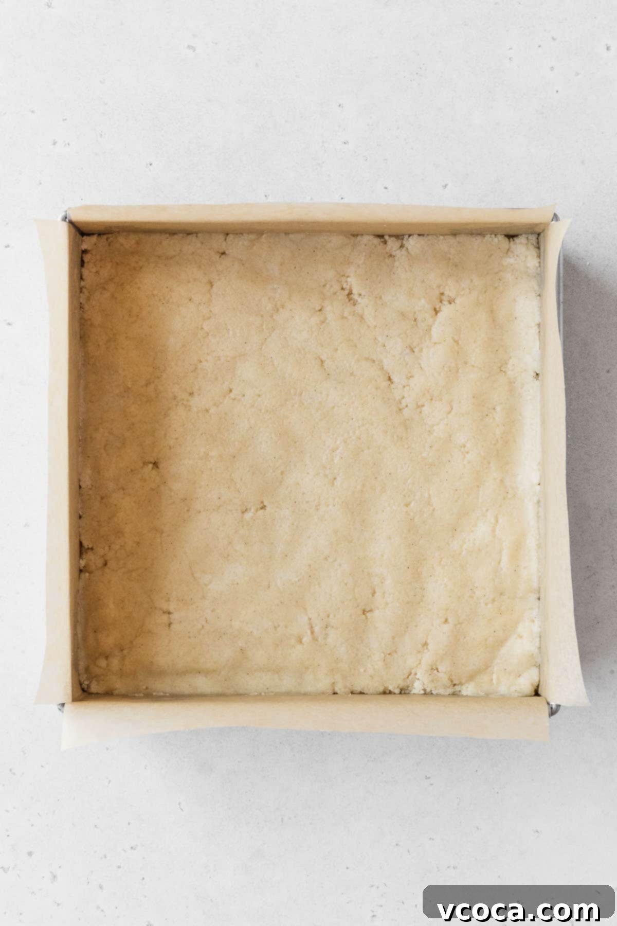 Bright and Zesty Dairy Free Lemon Bars 8 A metal baking pan of the dairy-free shortbread before baking, pressed into an even layer.