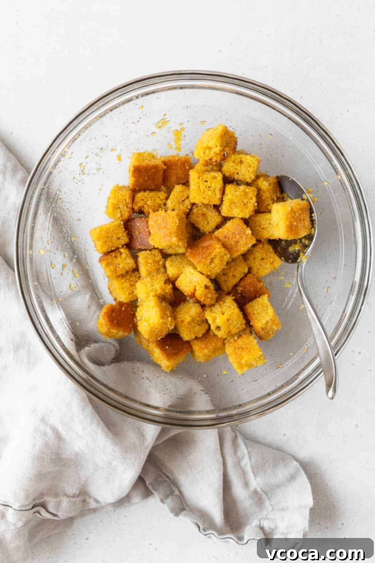 A large mixing bowl of the corn bread croutons before baking.