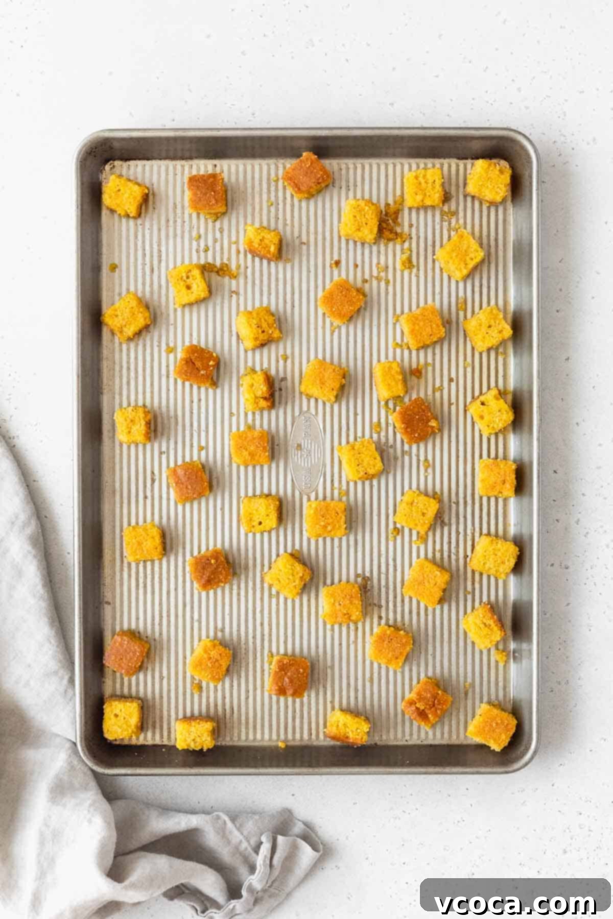 The cornbread croutons on a rimmed cookie sheet before baking.