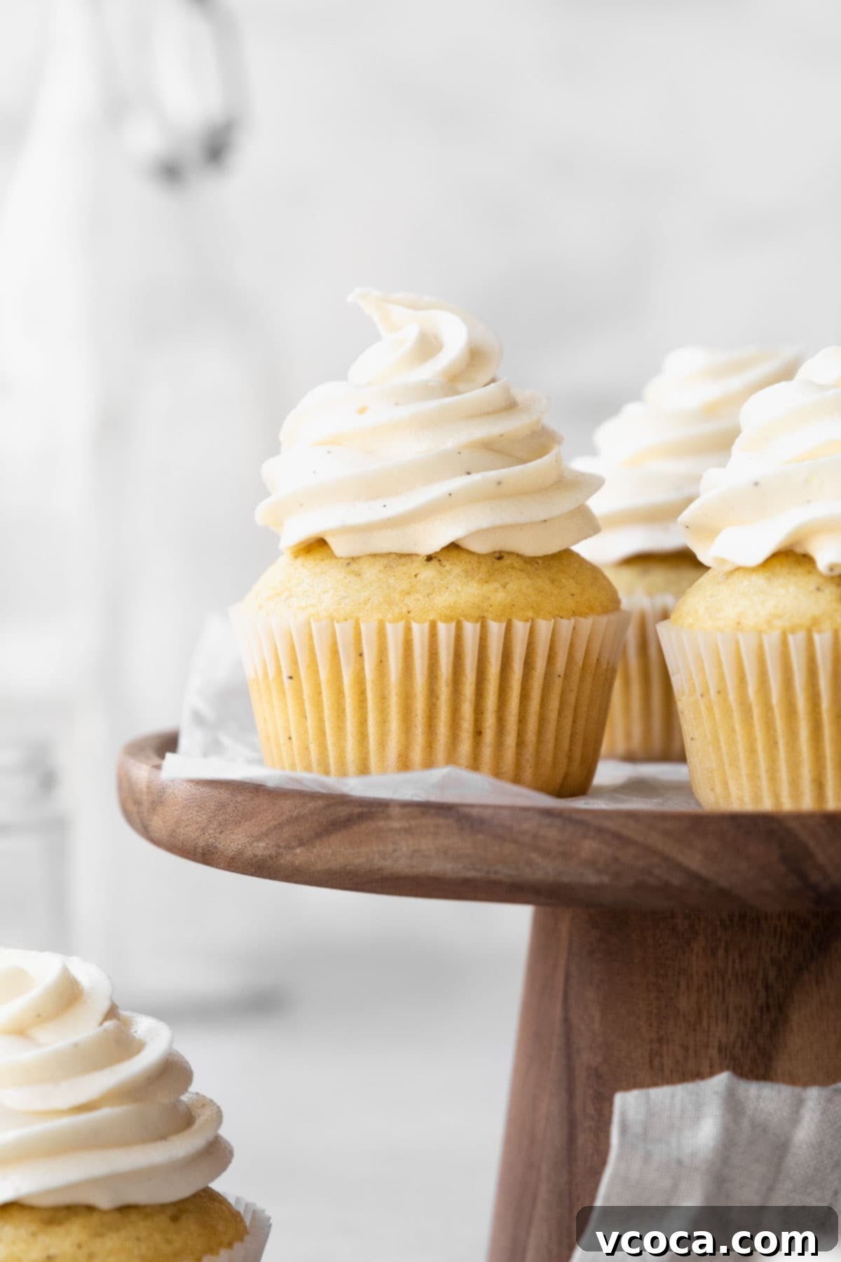 27 Reader-Favorite Gluten-Free Dairy-Free Treats 6 Dairy-free vanilla cupcakes on a wooden cake stand.