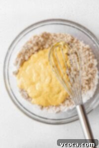A mixing bowl of the wet ingredients added into the dry ingredients.