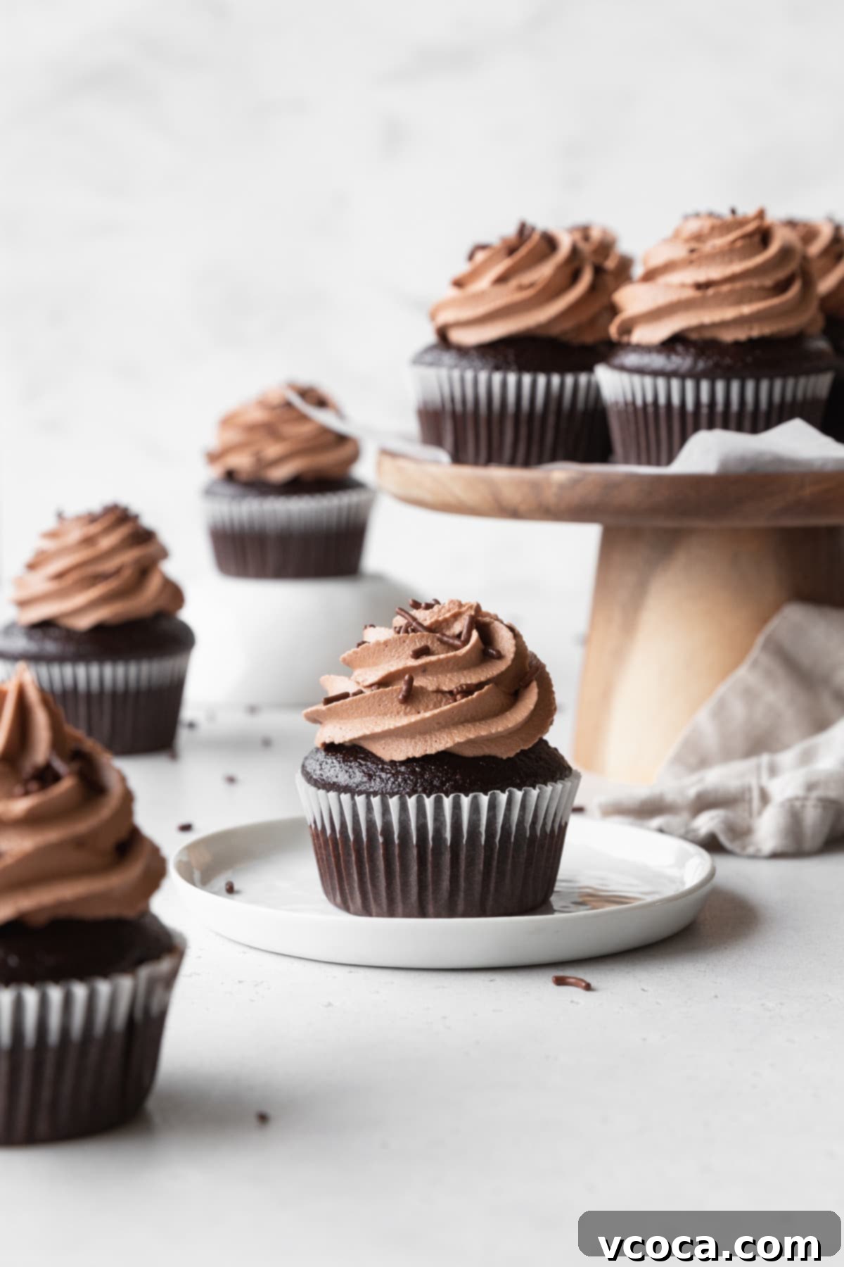 Velvety Chocolate Cupcakes 16 Chocolate cupcakes with chocolate cream cheese frosting scattered around.