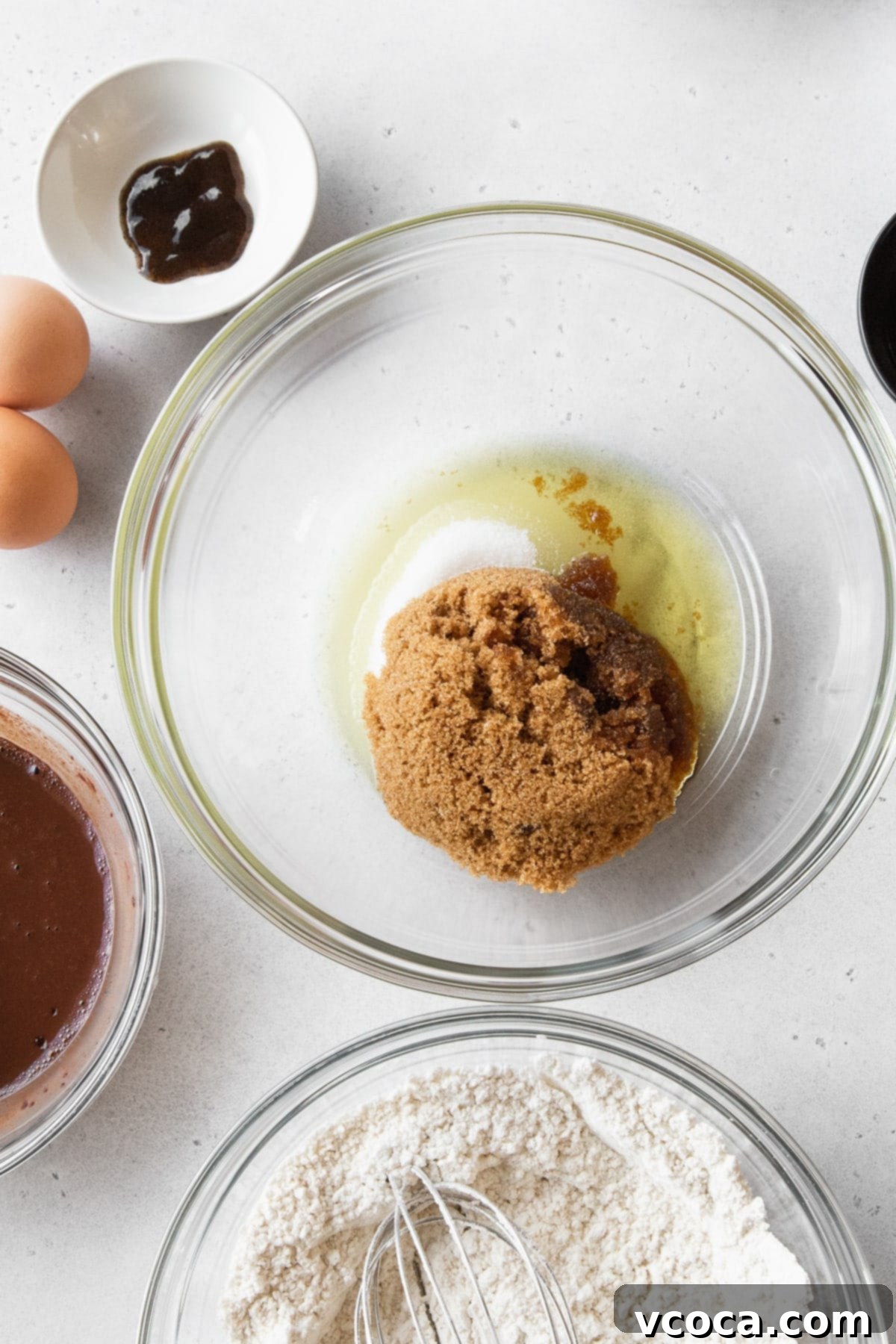 Velvety Chocolate Cupcakes 7 Brown sugar, granulated sugar, and oil in a glass bowl.