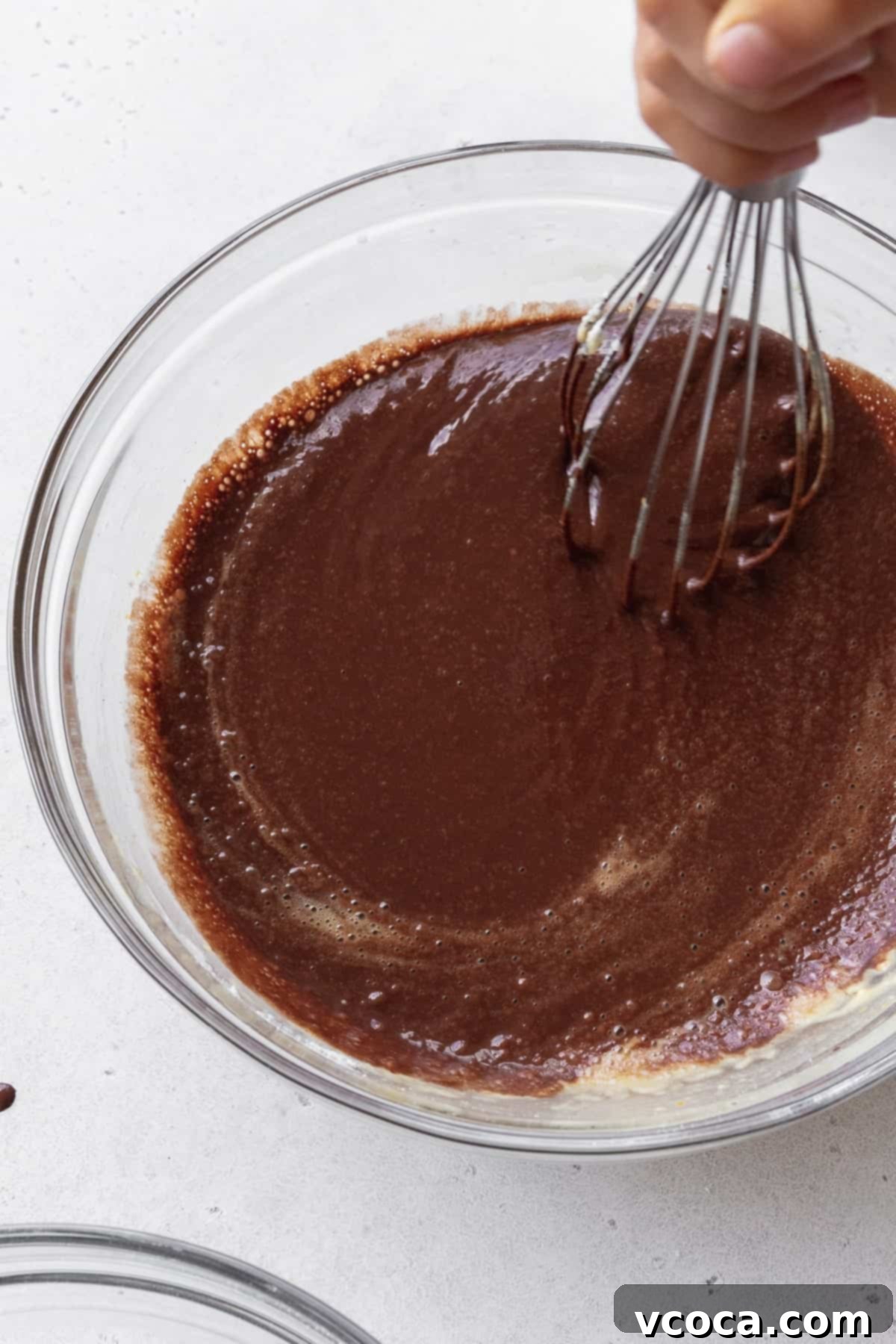 Velvety Chocolate Cupcakes 10 Chocolate cupcake batter being mixed with a whisk.