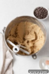 A glistening mixture of butter, sugar, and egg in a metallic bowl, expertly combined.