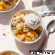 Homemade Peach Cobbler 4 A bowl of peach cobbler with canned peaches and a scoop of vanilla ice cream.
