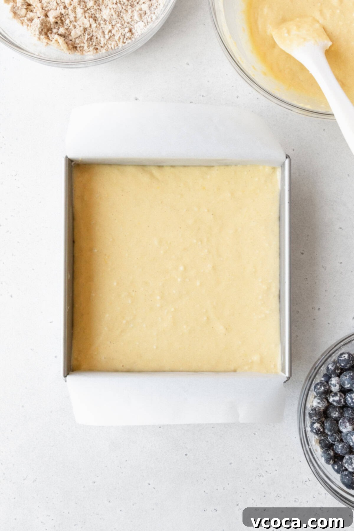 Blueberry Coffee Cake 12 Cake batter in a square pan, forming the base layer for the blueberry coffee cake.