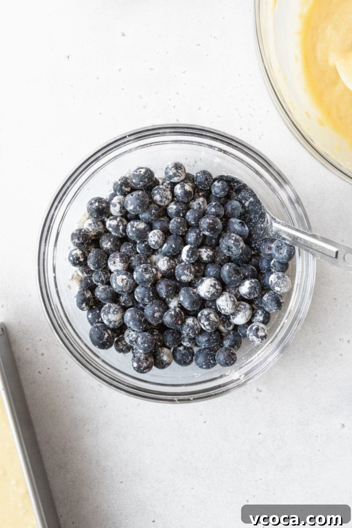 Blueberry Coffee Cake 7 Fresh blueberries in a clear glass bowl, lightly tossed with flour to prevent sinking.