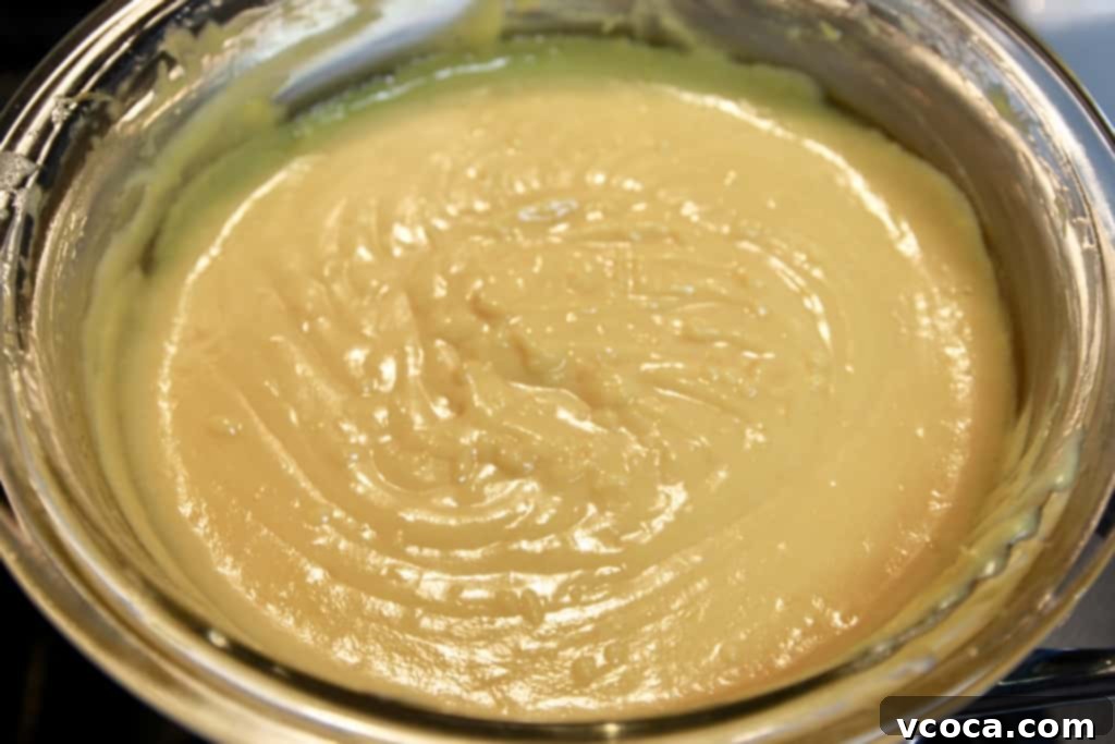 Zesty Grapefruit Tart 4 Close-up of grapefruit curd being whisked in a saucepan over heat.