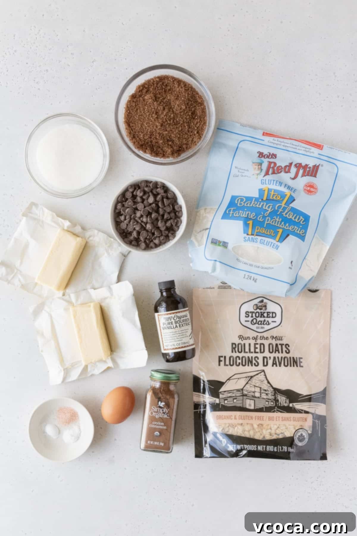 Delicious Gluten-Free Oatmeal Cookies 3 All the essential ingredients for making gluten-free oatmeal cookies, including butter, sugars, gluten-free flour, certified gluten-free oats, and chocolate chips, neatly laid out on a clean grey surface.