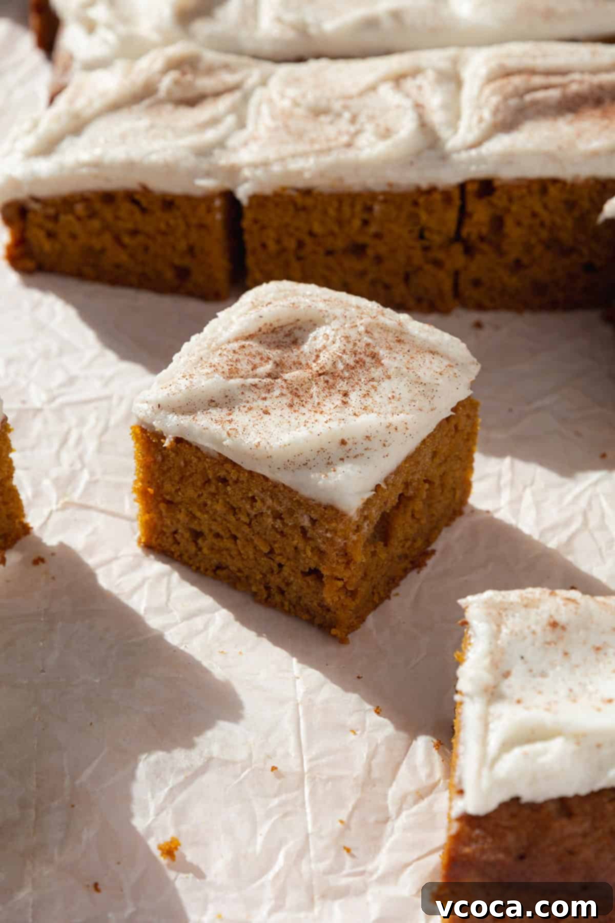 Spiced Pumpkin Squares 2 A slice of moist homemade pumpkin bars with creamy cream cheese frosting, a perfect fall dessert.
