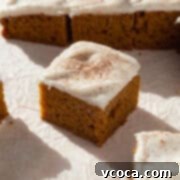 Spiced Pumpkin Squares 14 A perfectly frosted pumpkin bar with cream cheese, dusted with cinnamon on top, ready to eat.