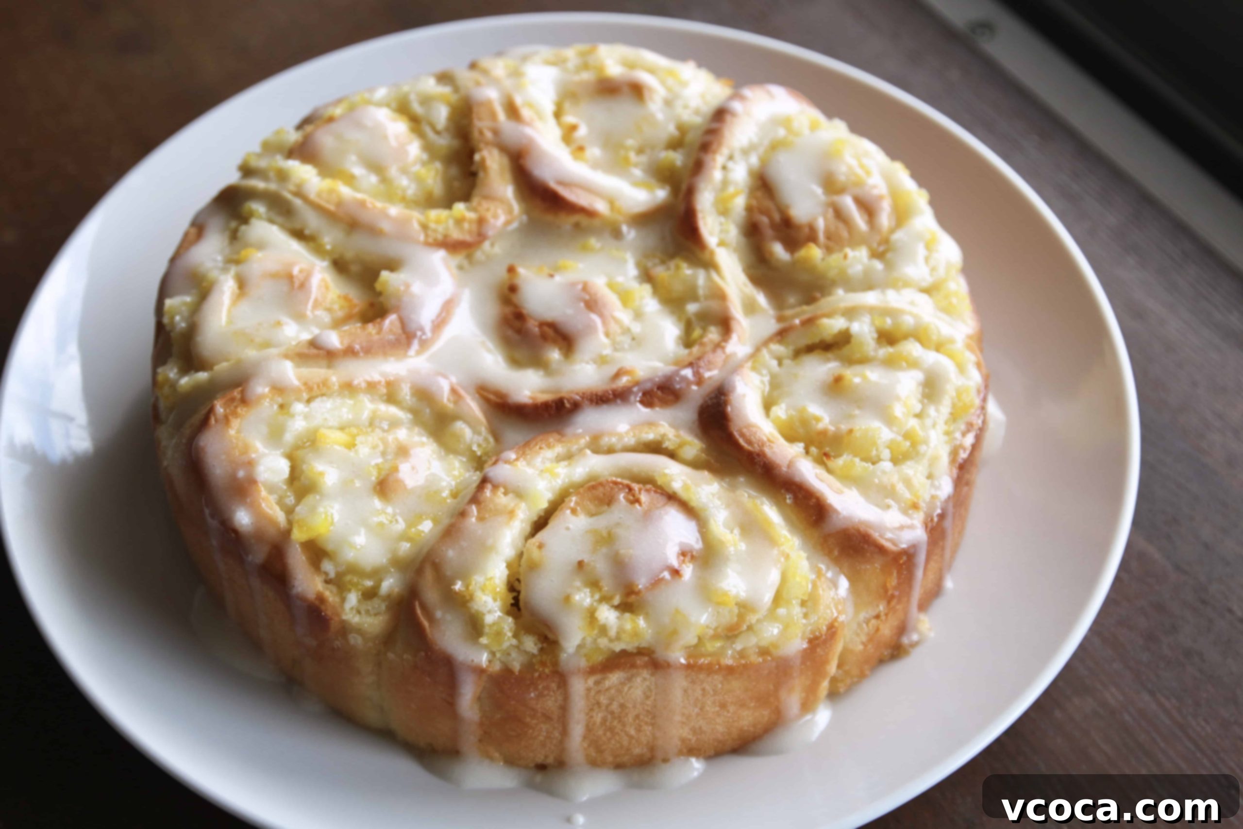 Tropical Piña Colada Swirls 2 Fluffy Piña Colada rolls on a plate, drizzled with coconut cream frosting