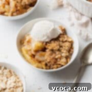 Comforting Gluten-Free Apple Crisp 5 A bowl of gluten free apple crisp with a scoop of vanilla ice cream on top.