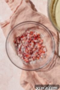 Diced strawberries coated in flour in a glass bowl.